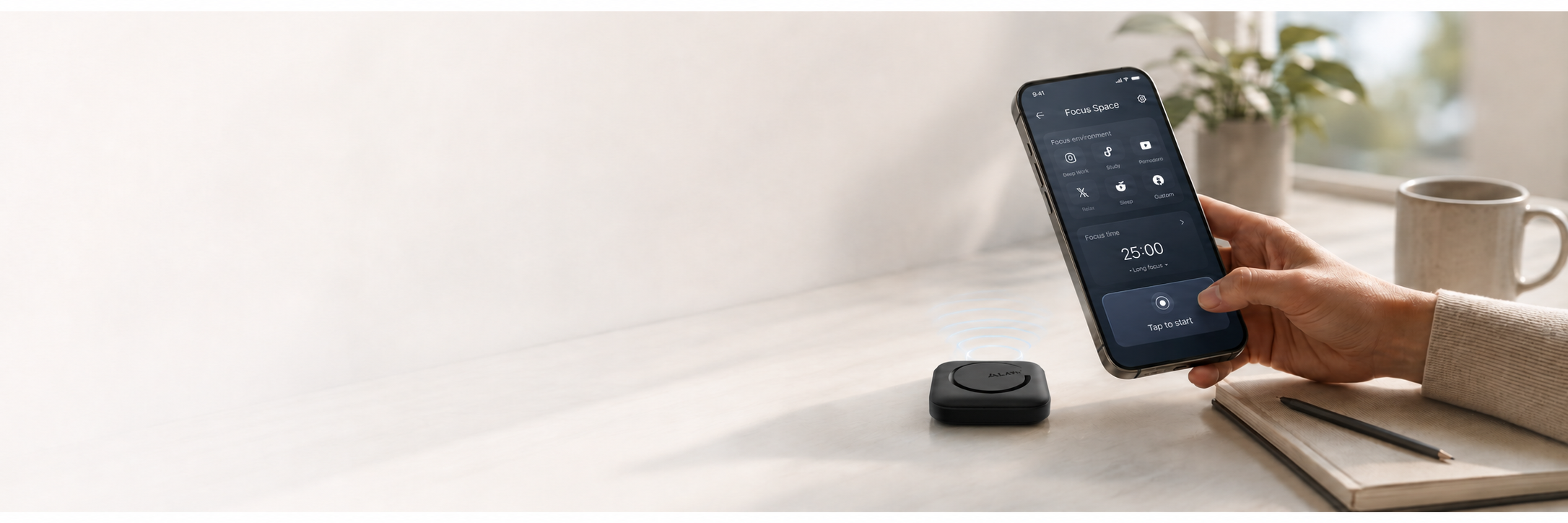 ALAFLY Tap focus device beside a phone on a bright desk